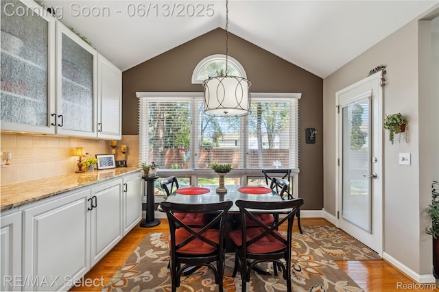 16483 Dawnlight Dr, Fenton, MI 48430 - dining area featuring light wood-style flooring, plenty of natural light, and vaulted ceiling