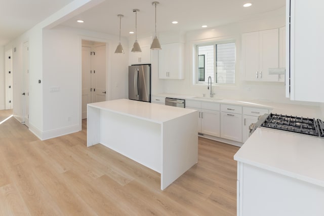 1439 Bennaville Ave, Birmingham, MI 48009 - kitchen with stainless steel appliances, light wood finished floors, recessed lighting, white cabinets, and a kitchen island