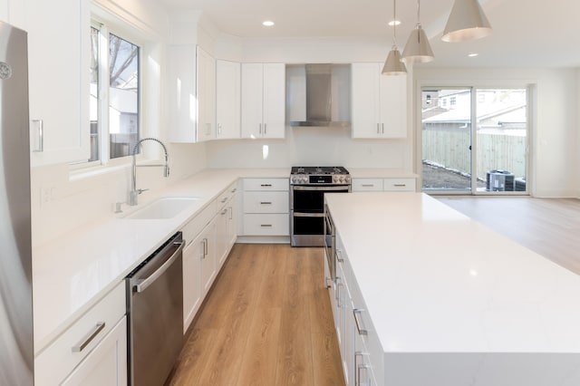 1439 Bennaville Ave, Birmingham, MI 48009 - kitchen with wall chimney range hood, appliances with stainless steel finishes, a center island, light wood-style flooring, and recessed lighting