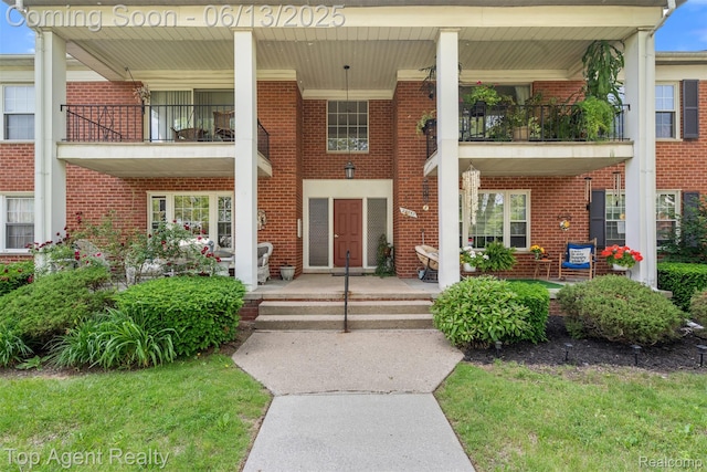27557 W Echo Vly Unit 153, Farmington Hills, MI 48334 - doorway to property with brick siding, a balcony, and covered porch