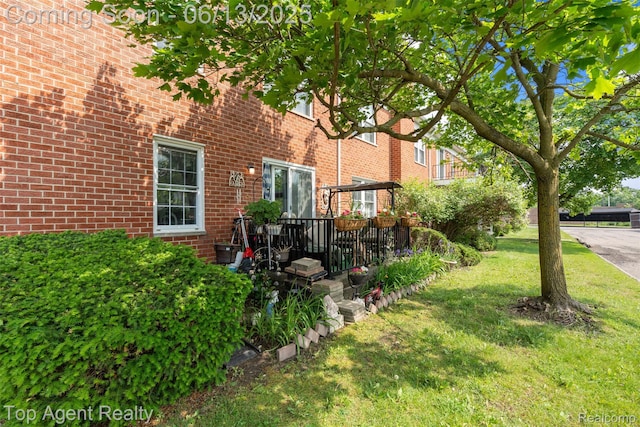 27557 W Echo Vly Unit 153, Farmington Hills, MI 48334 - view of side of property featuring a yard, a deck, and brick siding