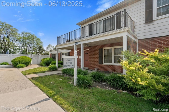 27557 W Echo Vly Unit 153, Farmington Hills, MI 48334 - view of front of house with a balcony, brick siding, and a gate