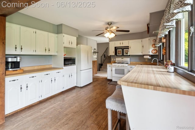 2970 Sand Beach Rd, Bad Axe, MI 48413 - kitchen featuring white appliances, dark wood-type flooring, ceiling fan, white cabinetry, and wood counters