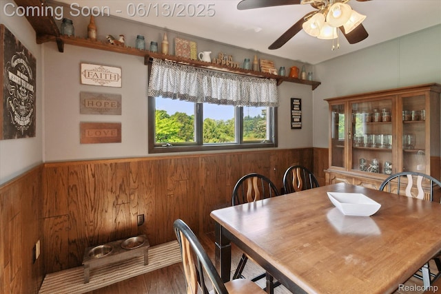 2970 Sand Beach Rd, Bad Axe, MI 48413 - dining area featuring wood walls, a wainscoted wall, a ceiling fan, and wood finished floors