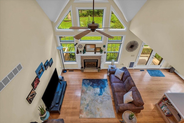 2082 Blackberry Ln, Howell, MI 48855 - living room featuring ceiling fan, high vaulted ceiling, a fireplace, plenty of natural light, and wood finished floors