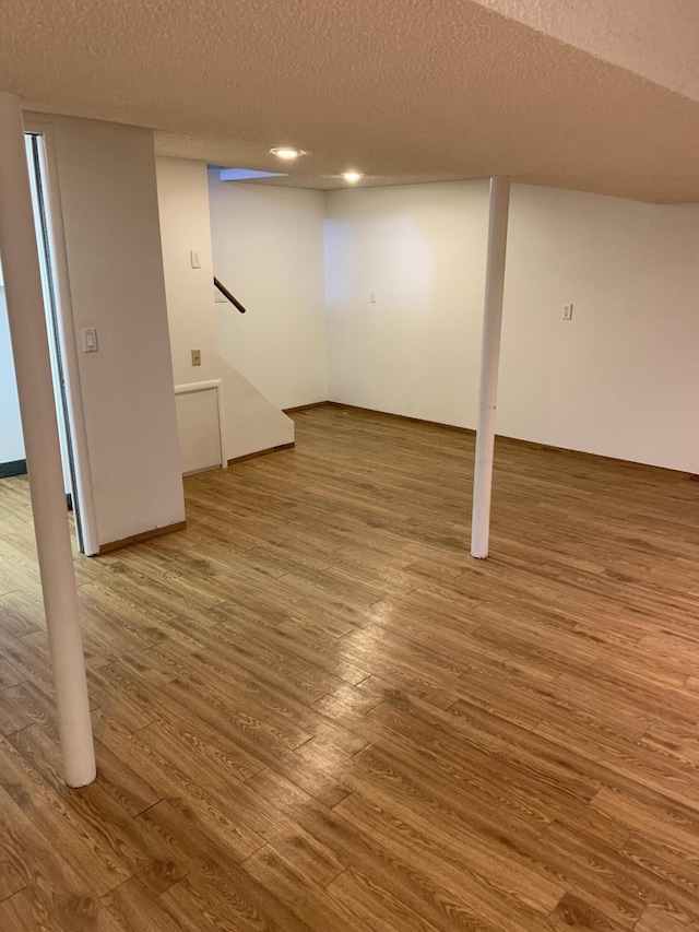 34203 Tomahawk St, Westland, MI 48185 - finished below grade area featuring wood finished floors, a textured ceiling, stairway, and recessed lighting