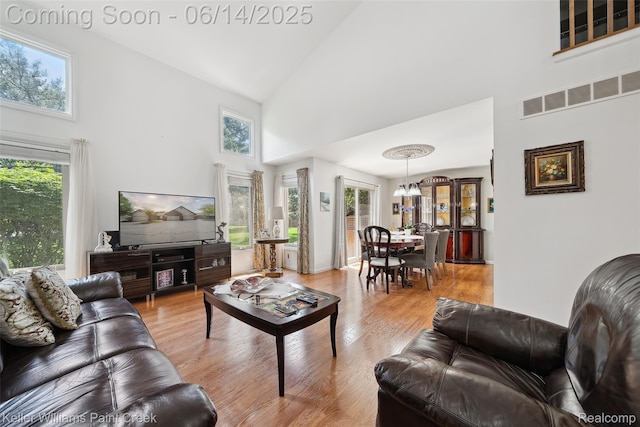 46860 High Meadows Ct, Macomb, MI 48044 - living area featuring high vaulted ceiling, light wood-type flooring, and a chandelier