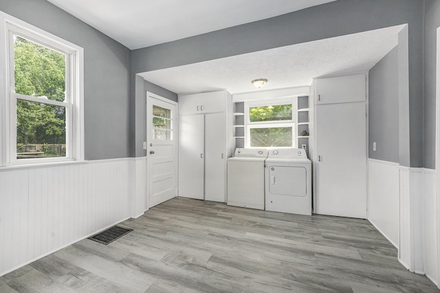1169 3rd St NW, Grand Rapids, MI 49504 - laundry room with washing machine and dryer, wainscoting, and light wood finished floors
