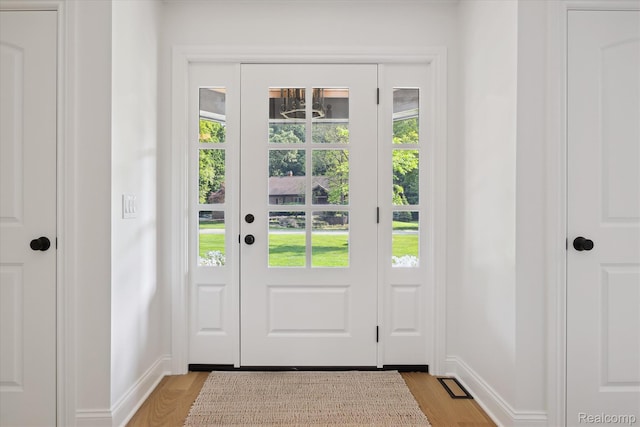 5695 Deerwood, Commerce Twp, MI 48382 - doorway with baseboards and light wood finished floors