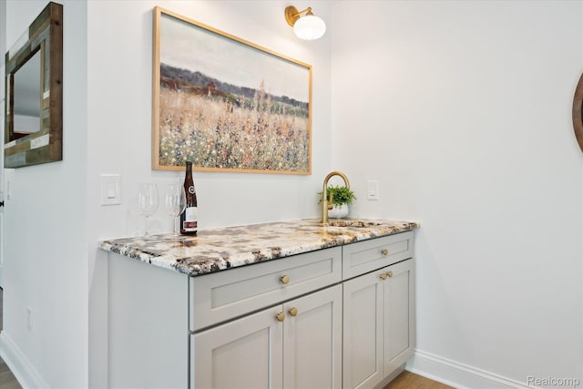 5695 Deerwood, Commerce Twp, MI 48382 - bar with a sink and light wood-type flooring