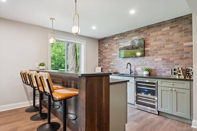 5695 Deerwood, Commerce Twp, MI 48382 - indoor wet bar with wine cooler, light wood-style flooring, pendant lighting, recessed lighting, and brick wall