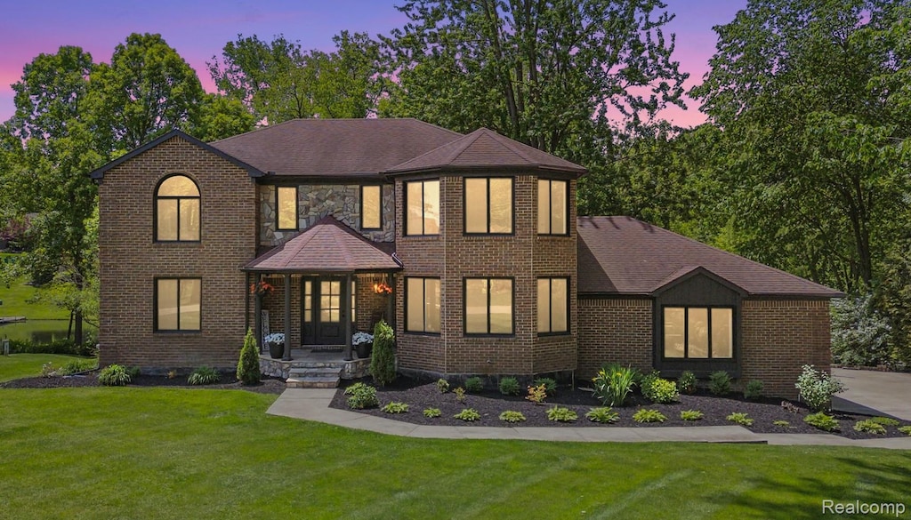 5695 Deerwood, Commerce Twp, MI 48382 - view of front of home featuring a front yard, brick siding, and a shingled roof