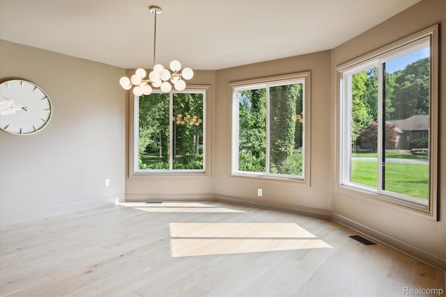 5695 Deerwood, Commerce Twp, MI 48382 - unfurnished room with plenty of natural light, a chandelier, and wood finished floors
