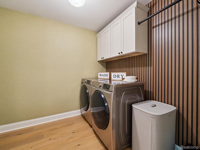 5695 Deerwood, Commerce Twp, MI 48382 - laundry room featuring cabinet space, light wood finished floors, and separate washer and dryer