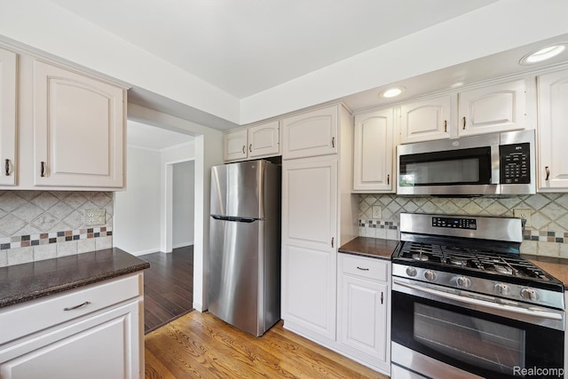 7302 Parkway Ct, Canton, MI 48187 - kitchen featuring stainless steel appliances, backsplash, light wood-style floors, dark stone countertops, and recessed lighting