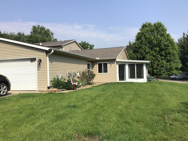 1077 Wedgewood Dr, Plainwell, MI 49080 - back of property with a garage, a lawn, and roof with shingles
