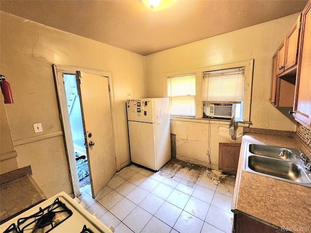 16612 Ilene St, Detroit, MI 48221 - kitchen with freestanding refrigerator, cooling unit, light tile patterned floors, and brown cabinets