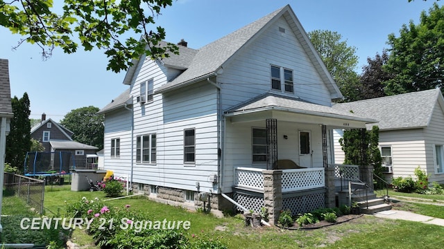 408 S Alp St, Bay City, MI 48706 - view of front facade featuring a porch, a front lawn, a trampoline, a chimney, and a shingled roof