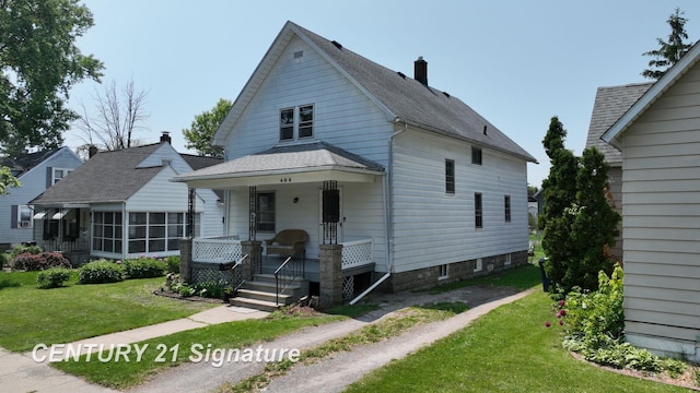 408 S Alp St, Bay City, MI 48706 - view of front of house featuring a porch, a front lawn, a chimney, and roof with shingles