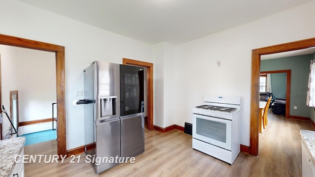 408 S Alp St, Bay City, MI 48706 - kitchen with white range with gas stovetop, stainless steel refrigerator with ice dispenser, light wood-style flooring, and light countertops