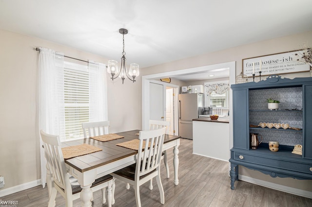 103 Lenawee St, Durand, MI 48429 - dining room featuring a chandelier, light wood-style floors, and baseboards