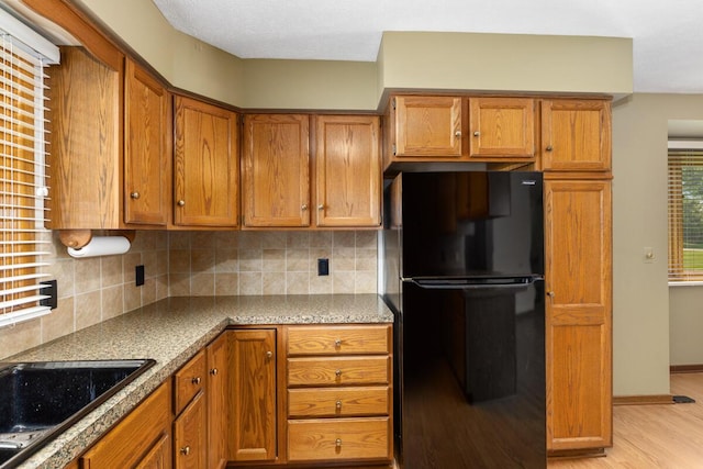 5157 Cliff Ct Unit 54, Hudsonville, MI 49426 - kitchen with freestanding refrigerator, brown cabinetry, tasteful backsplash, and light wood-style flooring