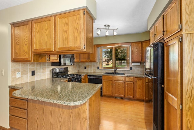 5157 Cliff Ct Unit 54, Hudsonville, MI 49426 - kitchen featuring black appliances, a sink, a peninsula, light wood-style flooring, and backsplash
