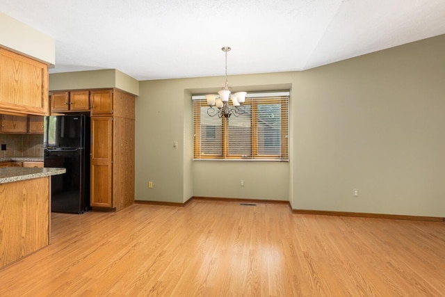 5157 Cliff Ct Unit 54, Hudsonville, MI 49426 - kitchen featuring freestanding refrigerator, a chandelier, light wood finished floors, brown cabinetry, and tasteful backsplash