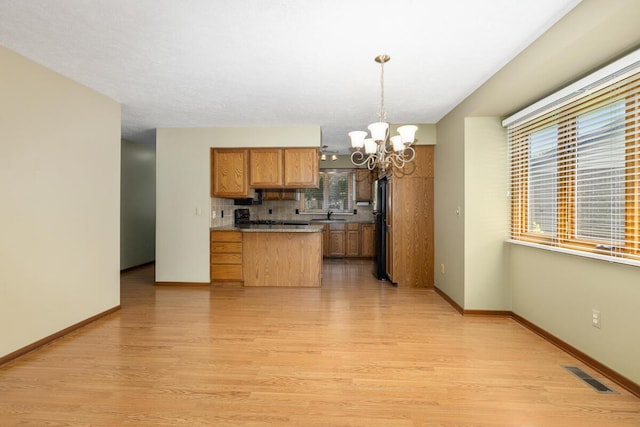 5157 Cliff Ct Unit 54, Hudsonville, MI 49426 - kitchen featuring a chandelier, freestanding refrigerator, light wood-style flooring, brown cabinetry, and decorative backsplash