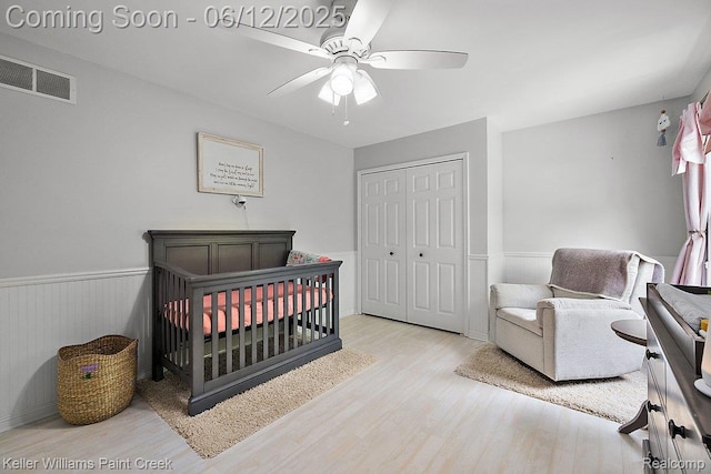 46341 Jasmine Ct, Chesterfield, MI 48047 - bedroom featuring wood finished floors, a wainscoted wall, a closet, a nursery area, and ceiling fan