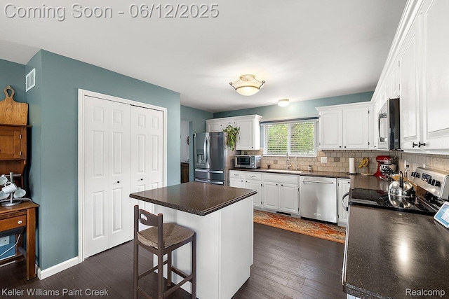 46341 Jasmine Ct, Chesterfield, MI 48047 - kitchen with appliances with stainless steel finishes, dark countertops, dark wood-type flooring, and white cabinetry
