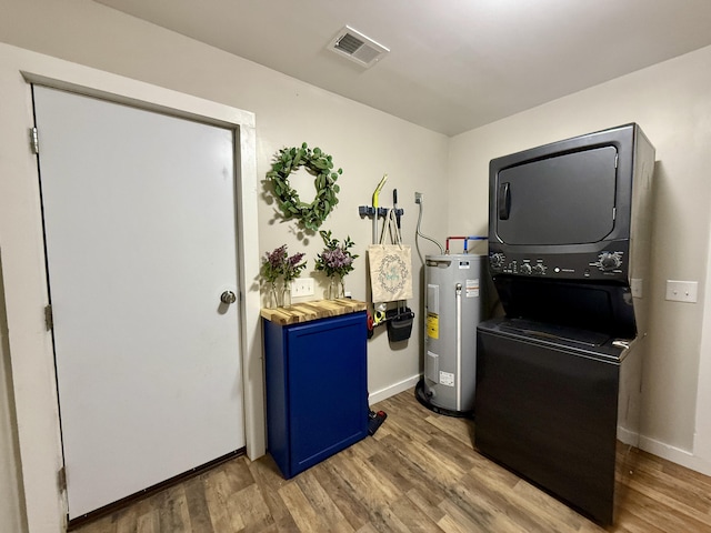 4223 S Harvard Ave, Baldwin, MI 49304 - miscellaneous room with stacked washing machine and dryer, water heater, wood finished floors, and baseboards