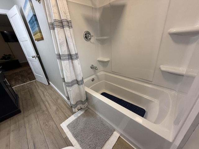 4223 S Harvard Ave, Baldwin, MI 49304 - full bath featuring wood finished floors, shower / bath combo, and baseboards
