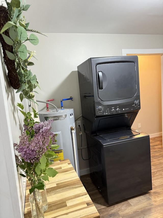 4223 S Harvard Ave, Baldwin, MI 49304 - laundry room with stacked washer / dryer, electric water heater, wood finished floors, and baseboards