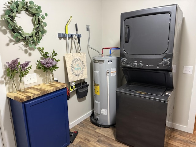 4223 S Harvard Ave, Baldwin, MI 49304 - laundry area with electric water heater, stacked washing machine and dryer, dark wood-style floors, and baseboards
