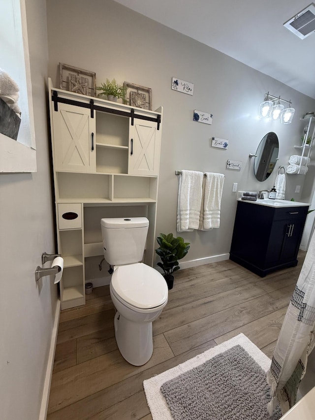 4223 S Harvard Ave, Baldwin, MI 49304 - bathroom featuring toilet, wood finished floors, vanity, and baseboards