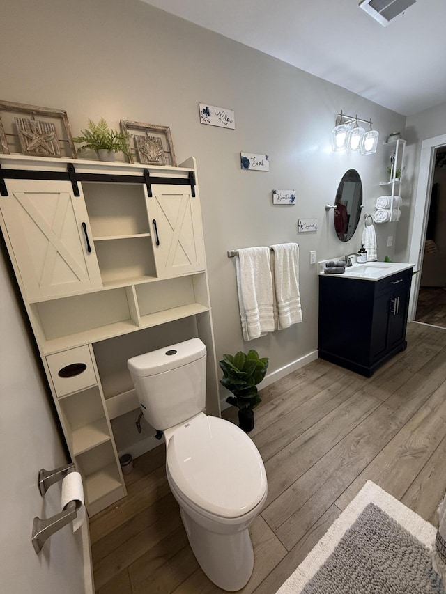 4223 S Harvard Ave, Baldwin, MI 49304 - bathroom featuring wood finished floors, toilet, vanity, and baseboards