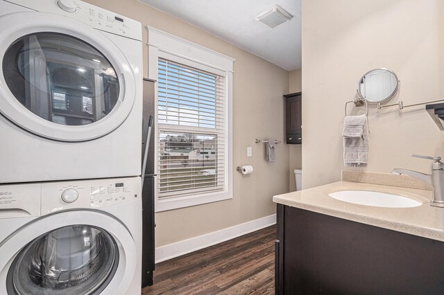 119 E Eliza St, Schoolcraft, MI 49087 - laundry room featuring stacked washer / drying machine, dark wood finished floors, and baseboards