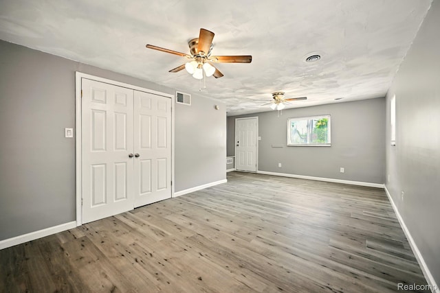2070 Harwine St, Flint, MI 48532 - unfurnished bedroom with wood finished floors, a closet, and a ceiling fan