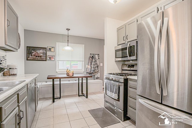 14711 Oldham St, Taylor, MI 48180 - kitchen with stainless steel appliances, gray cabinetry, light tile patterned floors, and hanging light fixtures
