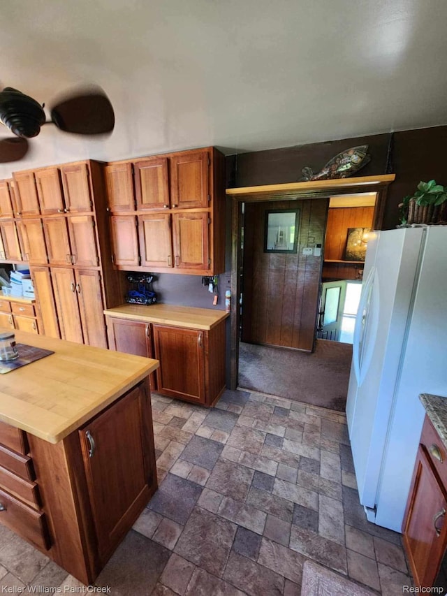 370 Wales Ridge Rd, Wales, MI 48027 - kitchen featuring freestanding refrigerator, dark stone finish floors, and brown cabinetry
