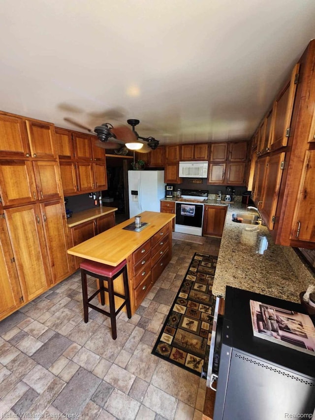 370 Wales Ridge Rd, Wales, MI 48027 - kitchen featuring white appliances, brown cabinetry, stone tile floors, and ceiling fan