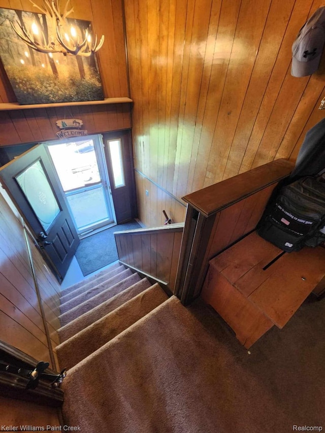 370 Wales Ridge Rd, Wales, MI 48027 - stairway with carpet floors, a chandelier, and wooden walls