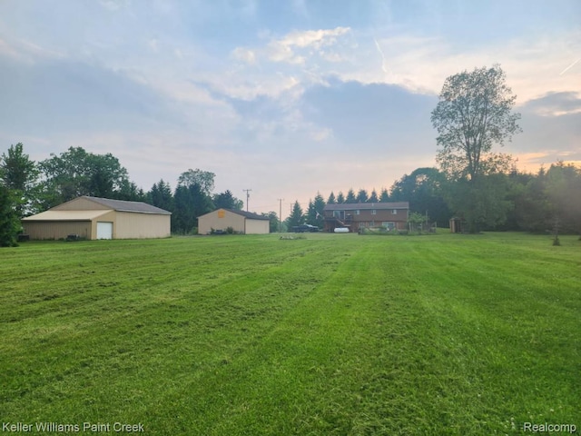 370 Wales Ridge Rd, Wales, MI 48027 - yard at dusk featuring a pole building, a lawn, an outdoor structure, and a garage