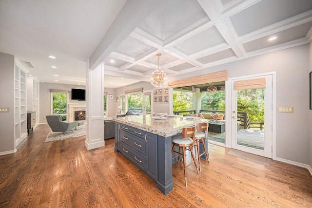 2002 Valleyview Dr, Ann Arbor, MI 48105 - kitchen featuring a kitchen breakfast bar, healthy amount of natural light, a lit fireplace, light wood finished floors, and coffered ceiling