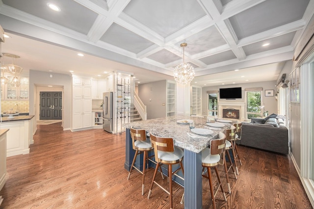2002 Valleyview Dr, Ann Arbor, MI 48105 - dining room with stairway, coffered ceiling, a chandelier, wood finished floors, and a lit fireplace