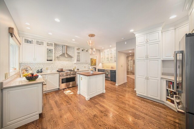 2002 Valleyview Dr, Ann Arbor, MI 48105 - kitchen featuring stainless steel appliances, wall chimney exhaust hood, a kitchen island, white cabinets, and recessed lighting