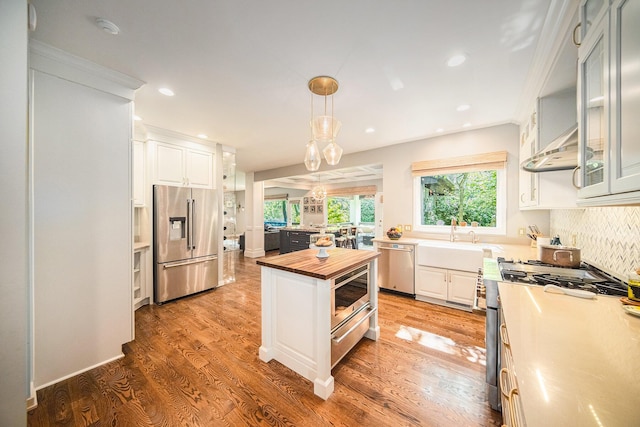 2002 Valleyview Dr, Ann Arbor, MI 48105 - kitchen with stainless steel appliances, butcher block counters, a sink, under cabinet range hood, and white cabinets