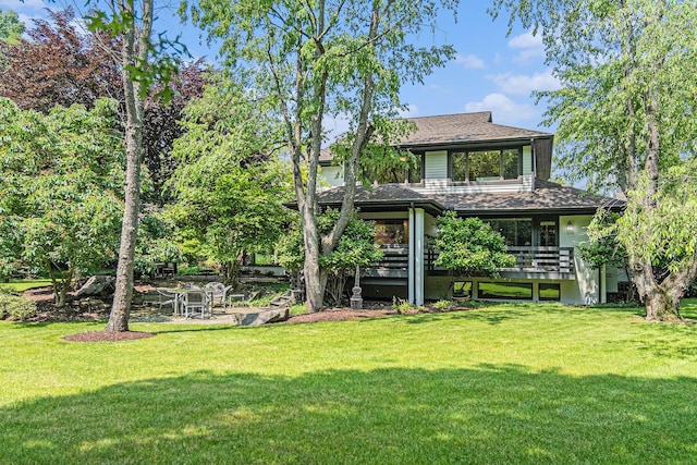 2002 Valleyview Dr, Ann Arbor, MI 48105 - back of property with a lawn, roof with shingles, a deck, and a patio area