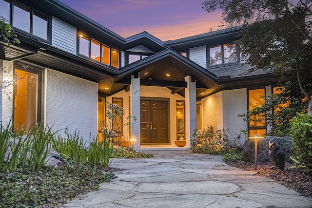 2002 Valleyview Dr, Ann Arbor, MI 48105 - exterior entry at dusk with brick siding and a porch